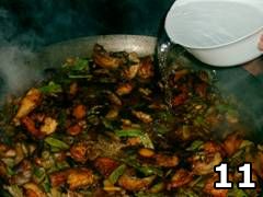 Foto di persona che aggiunge brodo nella paella valenciana